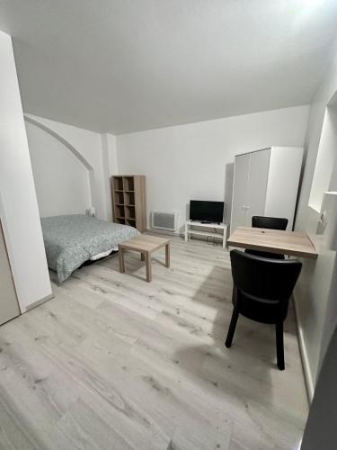 une chambre avec un lit, un bureau et une table dans l'établissement 02 Studio Immeuble Le GD, à Jarny