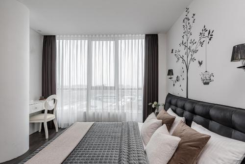 een slaapkamer met een groot bed en een bureau in een kamer bij cohost I HighRise 65m2 Apt w- Balcony and garage parking, Self check-in in Vilnius