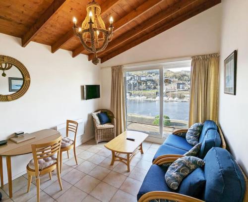 a living room with a blue couch and a table at Harbour Haven: Spectacular Views in Porthmadog