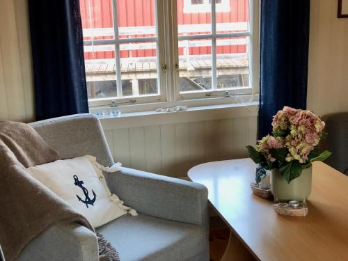a living room with a table and a vase of flowers at Nusfjord Ocean View Rorbu 19 in Ramberg