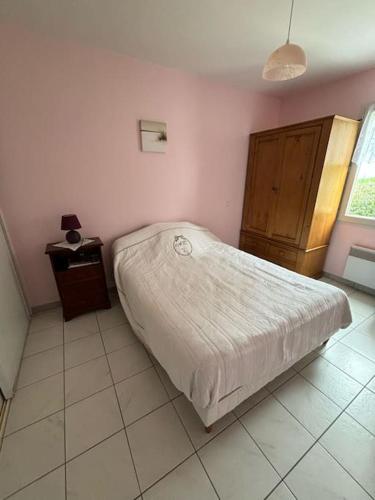 Habitación pequeña con cama y mesita de noche en Maison 4 personnes face mer, en La Brée-les-Bains