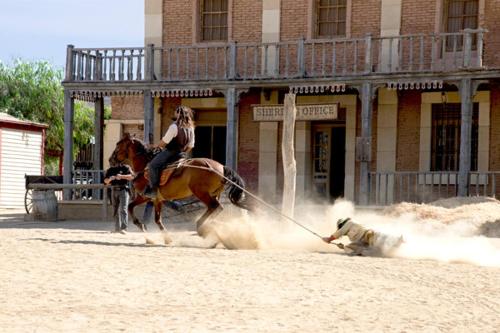 una mujer en un caballo tirando de un hombre con un perro en El Calon, mar y montaña, en Cuevas del Almanzora