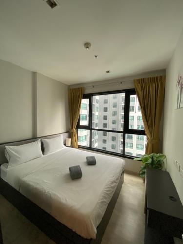 a bedroom with a large bed and a large window at The base in pattaya condo in Pattaya