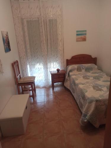 ein Schlafzimmer mit einem Bett, einem Tisch und einem Stuhl in der Unterkunft El Calon, mar y montaña in Cuevas del Almanzora