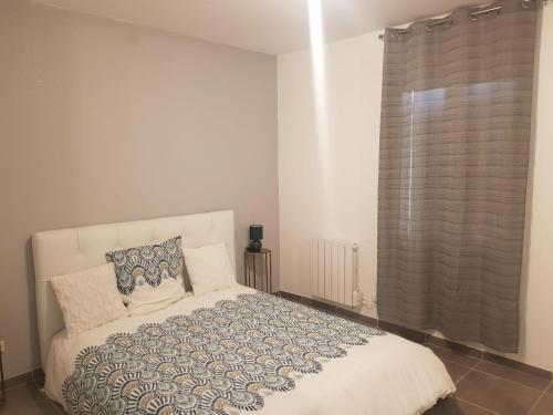 une chambre avec un lit blanc et une fenêtre dans l'établissement Appartement spacieux et confortable à Clermont-Dessous, terrasse, à Clermont-Dessous