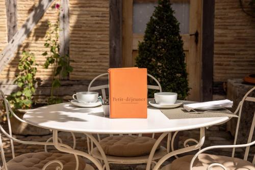 a table with a book sitting on top of it at Le Champ des Oiseaux Hôtel & Spa in Troyes
