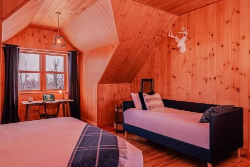 una camera con due letti in una stanza con pareti in legno di Private Hot Tub Sauna Ski Indoor Pool Nyctale a Mille-Isles