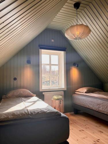 a attic room with two beds and a window at Jóhannshús- tradational Icelandic house in Hrepphólar