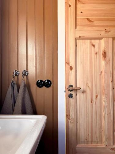 a bathroom with a white sink and a door at Jóhannshús- tradational Icelandic house in Hrepphólar
