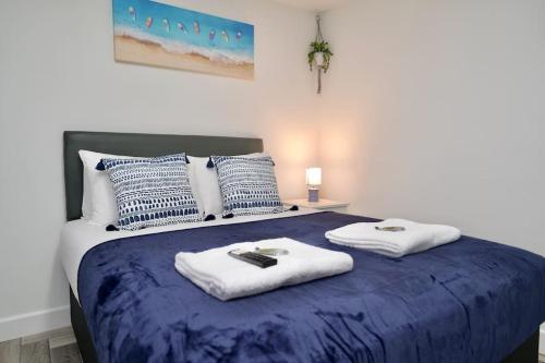 a bedroom with a blue bed with towels on it at Matlock Studio 7 - Coventry in Coventry