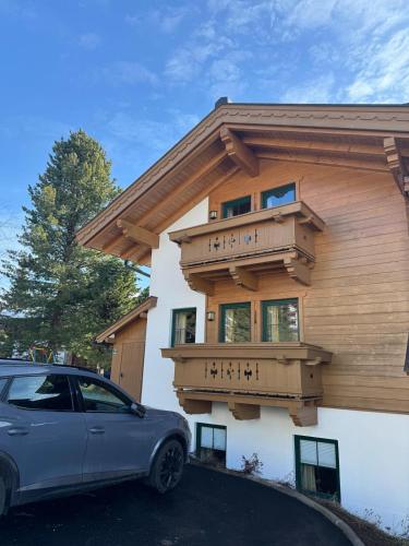 a car parked in front of a house with a balcony at Weinzeit Chalet in Königsleiten