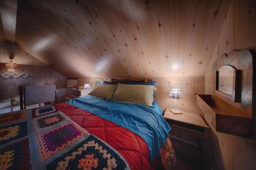 a bedroom with a bed in a wooden cabin at Rifugio del volpacchiotto - Piano Battaglia in Petralia Sottana