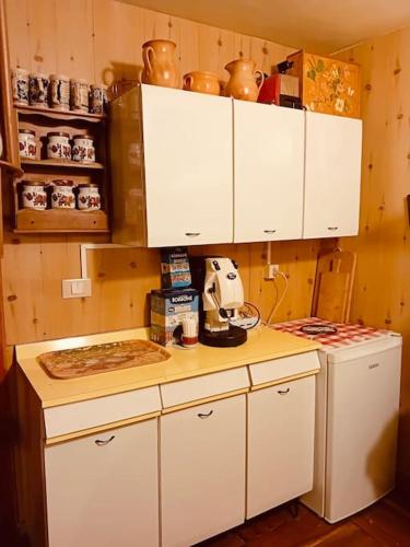 a kitchen with white cabinets and a counter top at Rifugio del volpacchiotto - Piano Battaglia in Petralia Sottana