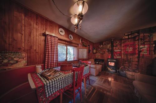 a living room with a table and chairs and a room with wooden walls at Rifugio del volpacchiotto - Piano Battaglia in Petralia Sottana