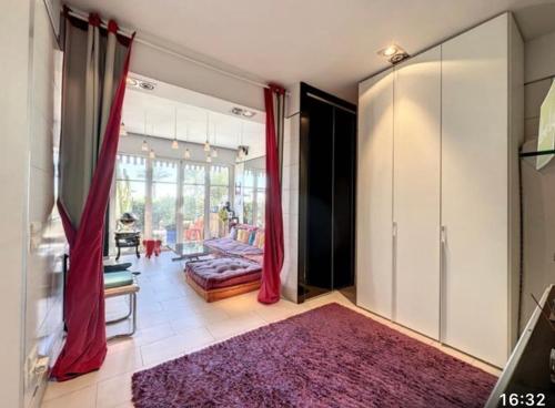 - un salon avec des rideaux rouges et un canapé dans l'établissement Appartement charmant en bord de mer à Nice 60 m² avec terrasse privée, à Nice