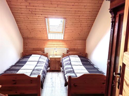 two beds in a small room with a window at Pension Claudia Güldenpfennig in Tangermünde