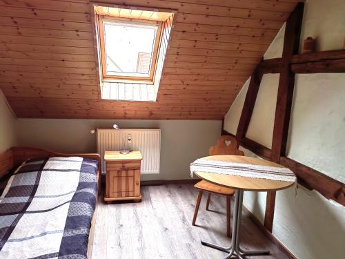 a bedroom with a bed and a table in a attic at Pension Claudia Güldenpfennig in Tangermünde