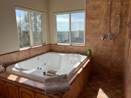 a large bath tub in a bathroom with windows at Stunning Mountaintop Resort in Placerville