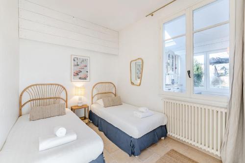 2 camas en una habitación con ventana en Maison des Embruns - 2 chambres et Jardin clos en Saint-Malo