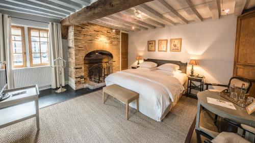 una camera con un grande letto e un camino di Le Champ des Oiseaux & Spa a Troyes