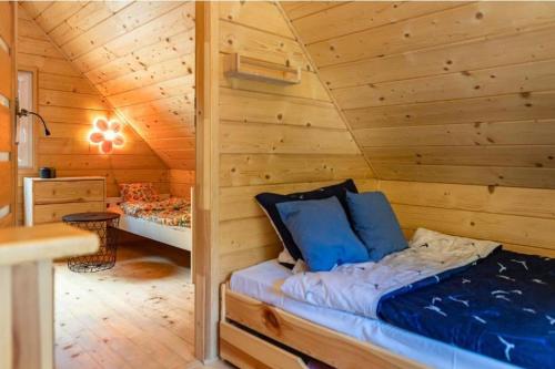 a log cabin with a bed in a room at Domek nad Zalewem Radkowskim in Radków