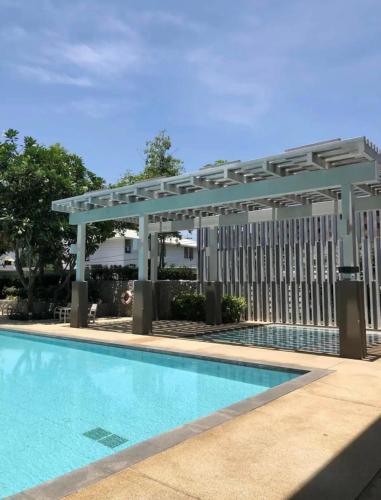 a swimming pool with a pergola next to a building at 350 METER BEACH , Center of the City in Hua Hin