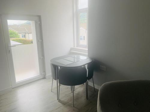 a small table and chairs in a room with a window at Bike Park 5 miles2-Bed cottage in Merthyr Vale in Merthyr Tydfil