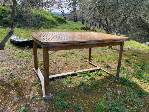 einem Holztisch auf einem Feld in der Unterkunft L’oiseau bleu in Cotignac