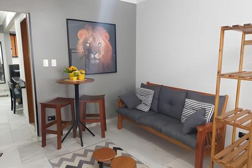 una sala de estar con un sofá y una mesa en Em frente ao quiosque Ocian na praia, pé na areia, en Praia Grande