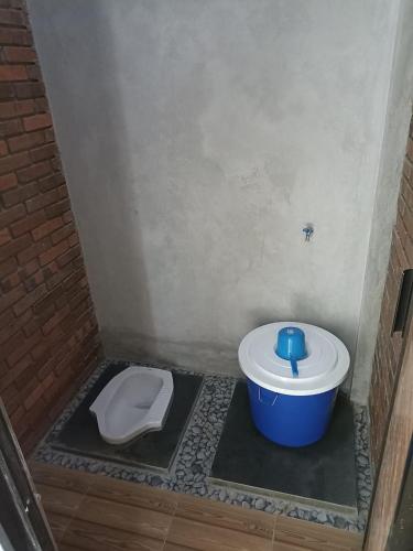 a small bathroom with a toilet and a bucket at Raihan Homestay in Pangenjurutengah