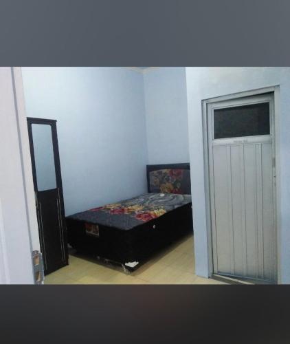 een kleine kamer met een bed en een deur bij Raihan Homestay in Pangenjurutengah