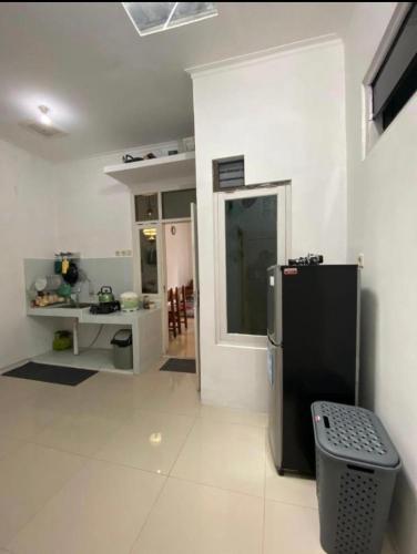 eine Küche mit einem schwarzen Kühlschrank im Zimmer in der Unterkunft Raihan Homestay in Pangenjurutengah