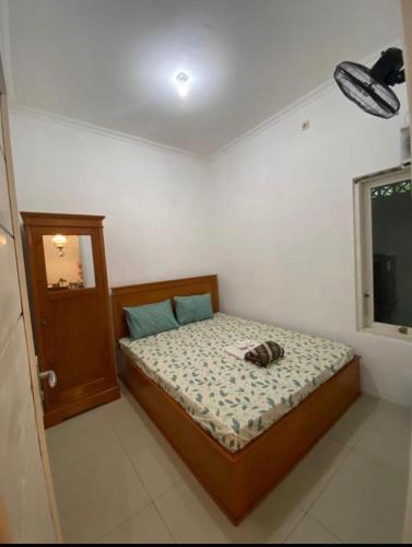 een slaapkamer met een bed met een hoed erop bij Raihan Homestay in Pangenjurutengah
