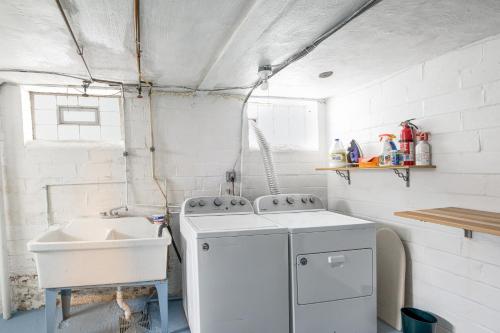 a kitchen with a sink and a washing machine at Convenient Cleveland Abode with Office and Home Gym in Cleveland