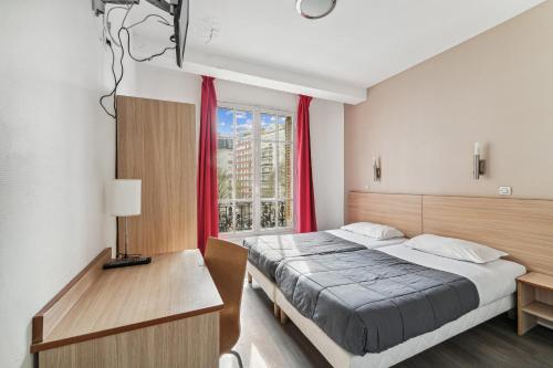 a bedroom with a bed and a window at Hotel Tolbiac in Paris