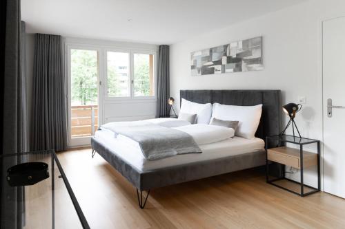 ein Schlafzimmer mit einem großen Bett und einem Fenster in der Unterkunft Apartment mit 3 Schlafzimmern in Engelberg