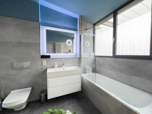 uma casa de banho com um lavatório, uma banheira e um WC. em Exklusives Leipzig City Apartment Aurora em Leipzig