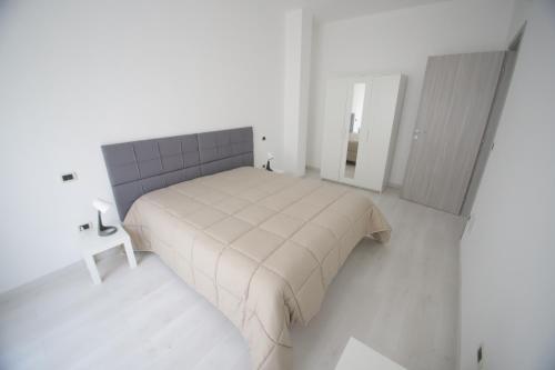 ein weißes Schlafzimmer mit einem Bett und einem Spiegel in der Unterkunft Il nascondiglio in San Ferdinando di Puglia