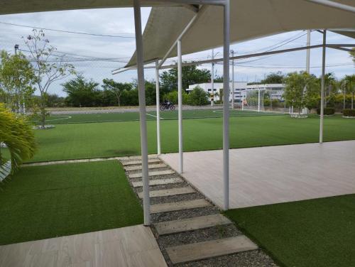 a pavilion with a lawn and a tennis court at Casa Sentido - Tu refugio campestre in Alvarado