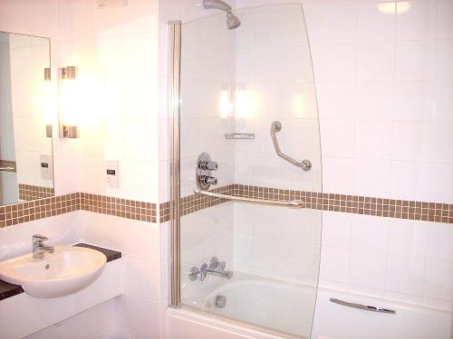 a bathroom with a shower and a sink and a tub at The Kingfisher in Bedford