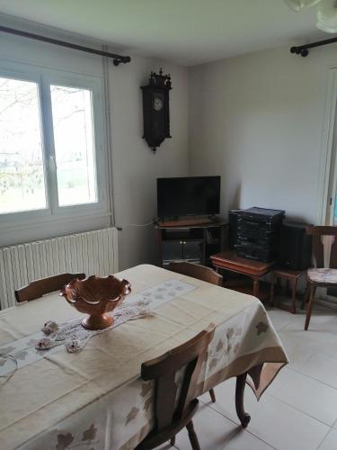 une salle à manger avec une table et une horloge au mur dans l'établissement Gîte du Gouthé, à Le Brouilh