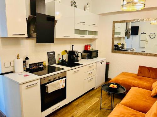 een keuken en een woonkamer met een bank en een tafel bij LOSSI 21/23 in Tartu
