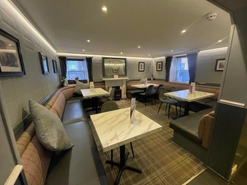a restaurant with tables and couches and tablesktop at Airlie Arms Hotel in Kirriemuir