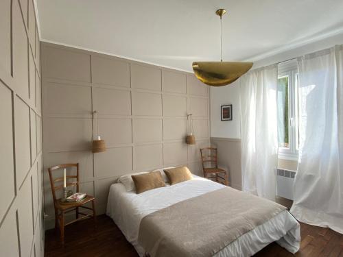 - une chambre avec un lit et une lampe pendant dans l'établissement Le 7, à Mesland