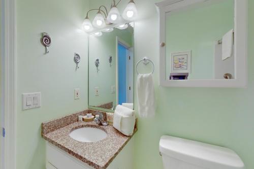 マートルビーチにあるEmerald Pointe 1-Cの洗面台と鏡のある白いバスルーム