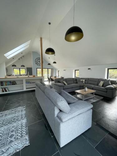 a living room with a couch and a table at Gulland 4 Bed Sleeps 8 with Hot tub in Treknow