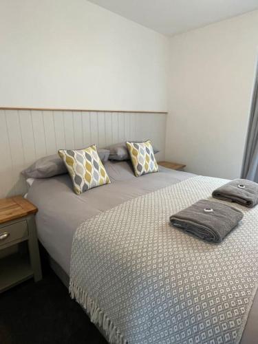 a bedroom with a bed with two pillows on it at Gulland 4 Bed Sleeps 8 with Hot tub in Treknow