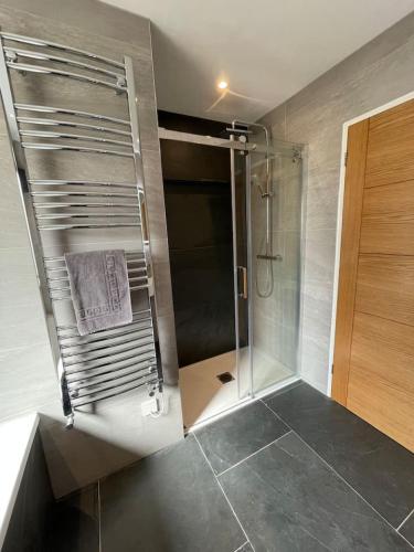 a shower in a bathroom with a glass shower stall at Gulland 4 Bed Sleeps 8 with Hot tub in Treknow