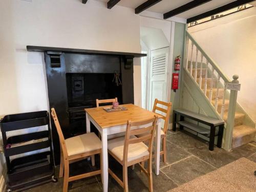 a dining room with a table and chairs and a staircase at Atlantic Cottage Port Isaac 2 bedroom with parking in Port Isaac