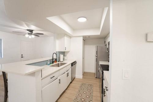 eine Küche mit weißen Schränken und einem Deckenventilator in der Unterkunft Beautiful 2 BR Mesa Riverview Apt, Close to 202 HW! in Mesa